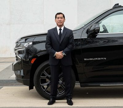 Private chauffeur Gilberto Sr. from Washington, D.C. waiting outside his vehicle.