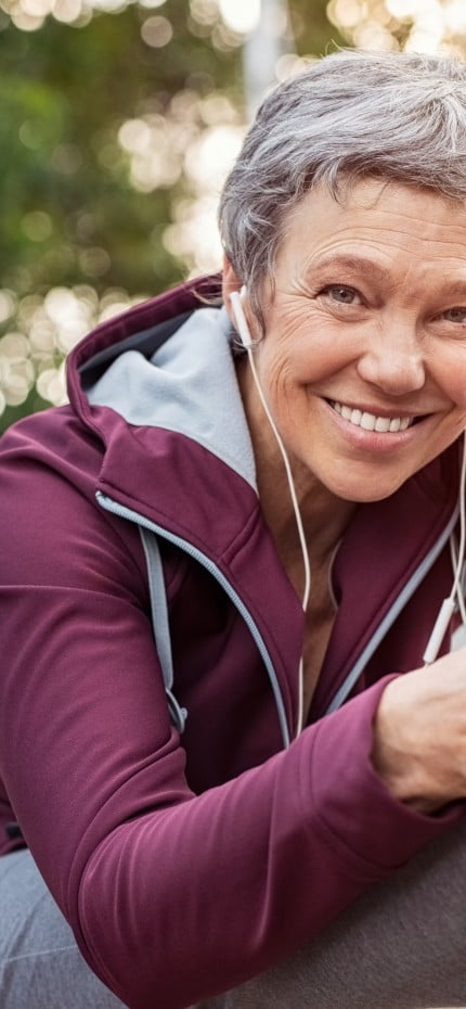 Senhora madura se alongando no Central Park, em Nova York, depois de correr