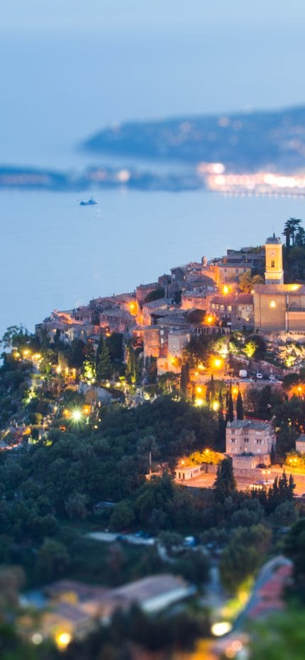el pueblo de eze y la peninsula de saint jean cap ferrat al atardecer, hora azul, desde la gran corniche,efecto de inclinacion y desplazamiento