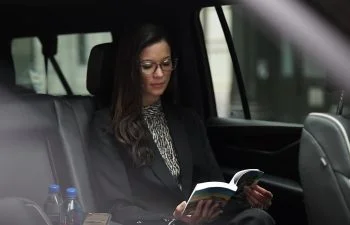 Mujer leyendo sentada en el asiento trasero de un vehículo