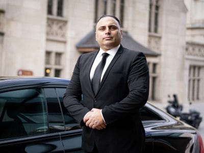 O motorista particular Cristian, de Genebra, do lado de fora de seu veículo.