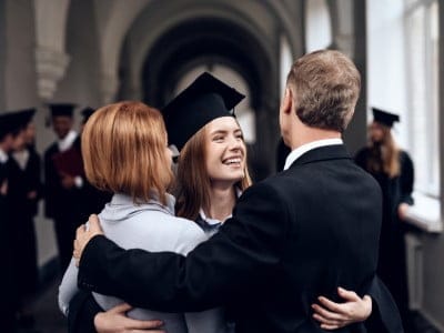 Os pais parabenizam o aluno que termina seus estudos na universidade. Ele se formou. Eles estão muito felizes com isso.