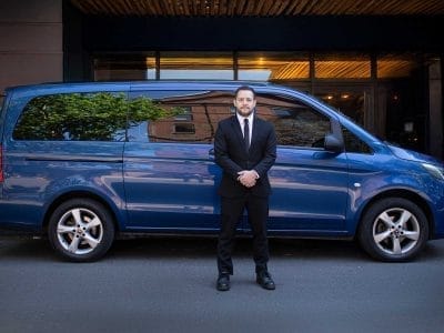 Private chauffeur Matías standing next to his vehicle