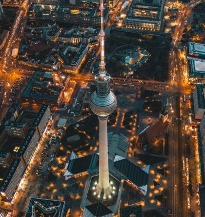 Berlin, Germany Alexanderplatz TV Tower after Sunset at Dusk with beautiful lit up Streets in orange lights of a Big City Cityscape, Aerial View HQ