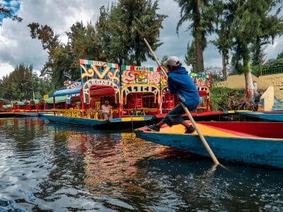 Xochimilco, Cidade do México, 25 de junho de 2019 - Jovem trajinero conduz e rema a trajinera no canal de Xochimilco.