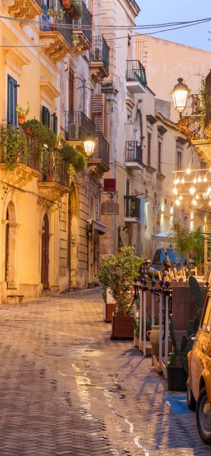 Siracusa, Itália, paisagem urbana e cena de rua no crepúsculo.