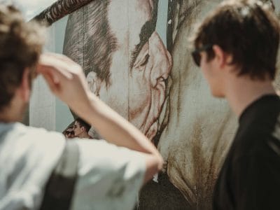 Jóvenes observando un mural de arte callejero en Berlín