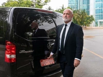 Motorista particular Rpbson, de São Paulo, esperando do lado de fora de seu veículo