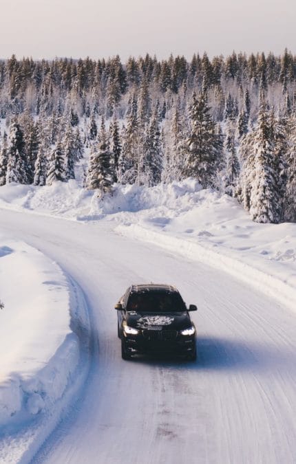 Coche circulando por una carretera nevada
