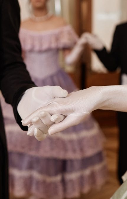 A senhora e o senhor de mãos dadas usando luvas
