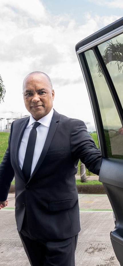 El chófer privado Oscar de San José de Costa Rica abriendo la puerta de su vehículo.