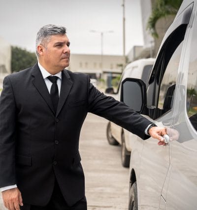El chófer privado Alexis de San José de Costa Rica, abriendo la puerta de su vehículo.