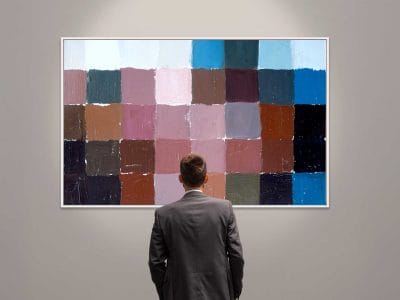 Homem olhando para uma pintura exposta em uma galeria.