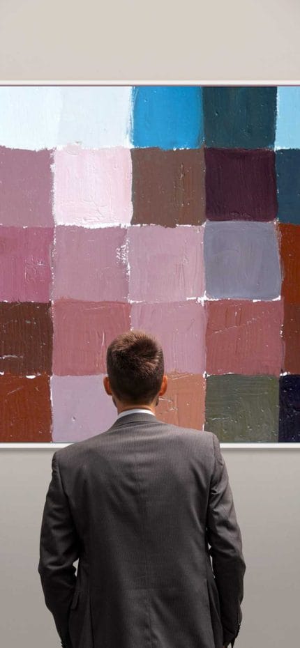 Man looking at an exposed painting in a gallery.