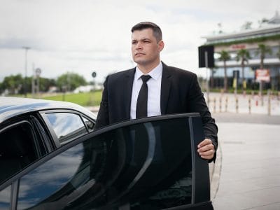 El chófer privado Julio de Porto Alegre fuera de su vehículo.