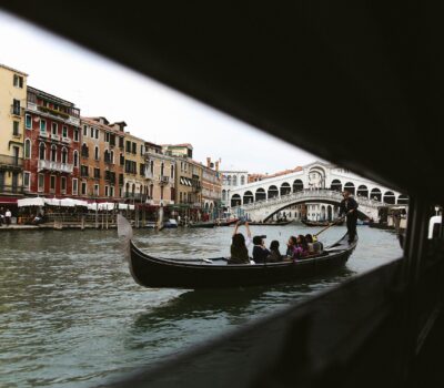 Detail of a gondola sailing through one of Venice's canals.