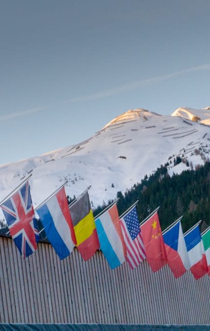 Davos, GR / Suiza - 15 de enero de 2020: el centro de congresos de Davos con banderas de naciones al amanecer durante el Foro Económico Mundial (WEF).