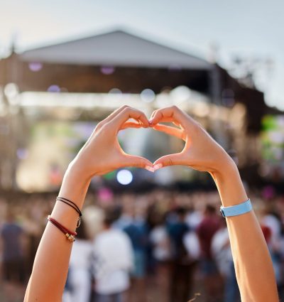 Attendants at a film festival. A young woman is making a heart shape with her hands.