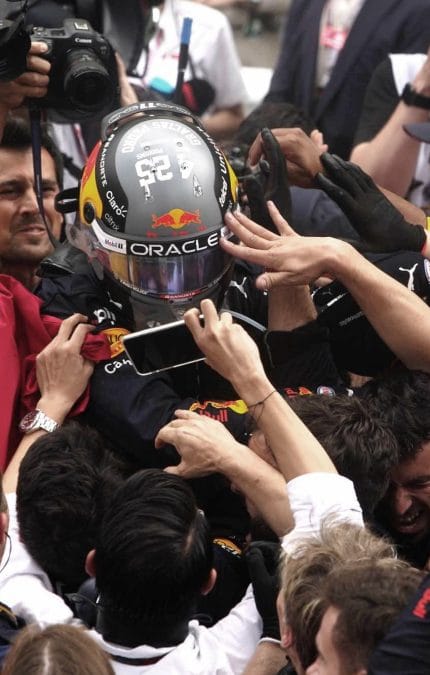 crowd celebrating with a F1 driver after a rece.