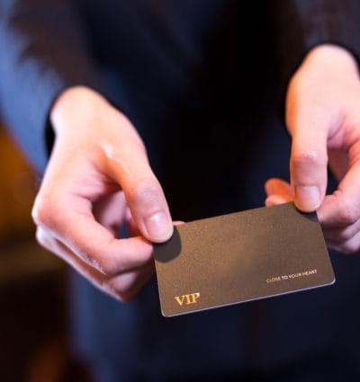 Hands of a man holding a VIP credit card