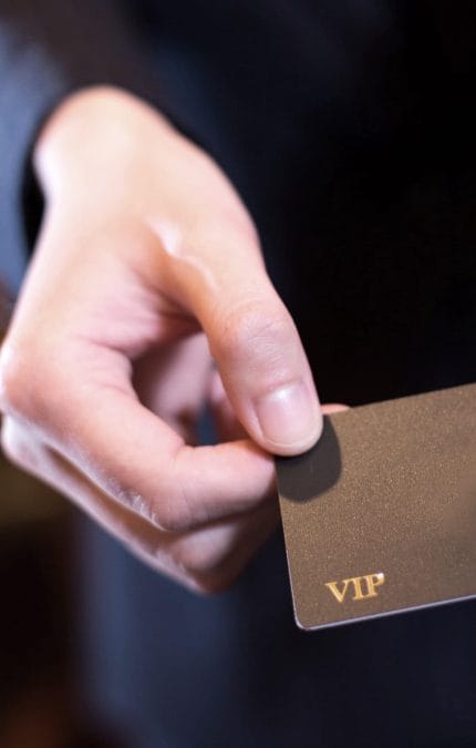 Primer plano de una mano que sostiene una tarjeta VIP.