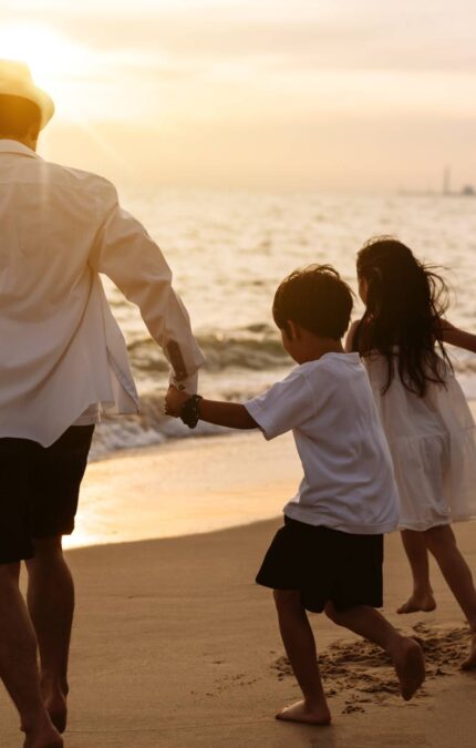 Família asiática feliz aproveita a praia, composta por pai, mãe, filho e filha, se divertindo brincando na praia durante as férias de verão. Família feliz com o conceito de estilo de vida de férias.