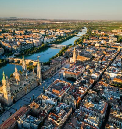 Spectacular sunset skyline of Zaragoza. View of the old town, Zaragoza Cathedral, and the Ebro River. Medieval and historical tourist destination in Aragon, Spain. Sunset spot with orange reflections.