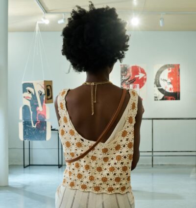 Mujer de espaldas observando piezas de arte en una exposición.