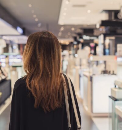 Mujer vista de espaldas dentro de unos grandes almacenes.