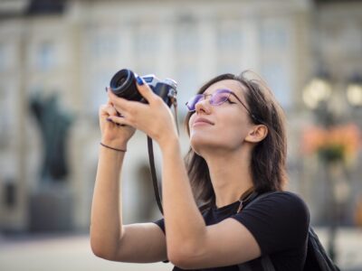 young woman photographing the cityscape during a private trip.