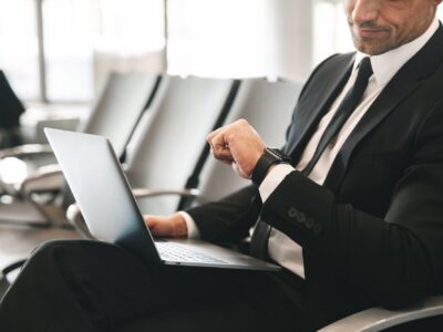 Executive checking the time while working in an airport lounge.