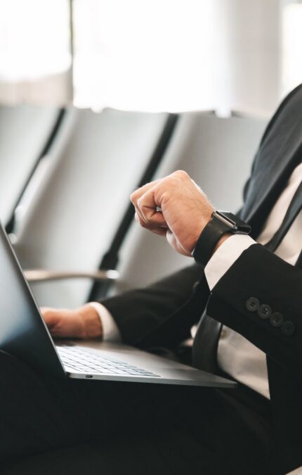 Executivo conferindo as horas enquanto trabalha em um lounge de aeroporto.