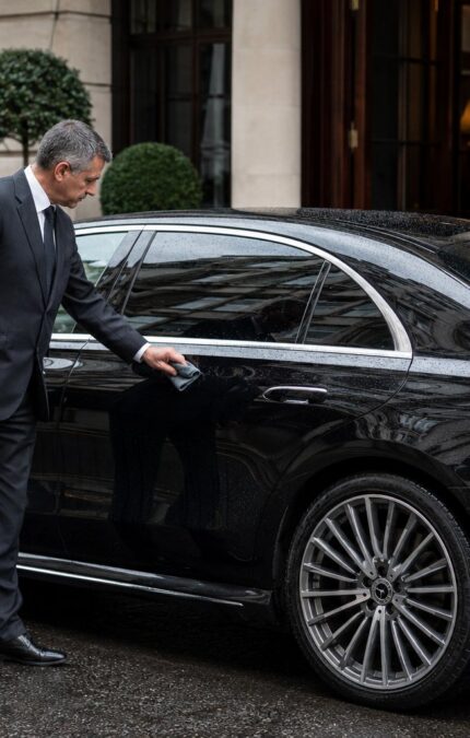 Chauffeur taking care of his business premium vehicle.